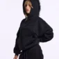 Modelo con sudadera negra Cold Culture Hairy mostrando la capucha de pelo y el bolsillo canguro