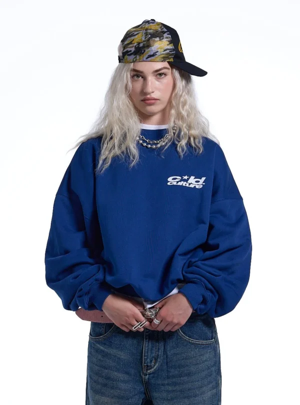 Modelo con sudadera Heart Ashtray de Cold Culture en azul oscuro, con detalle del logotipo blanco en el pecho
