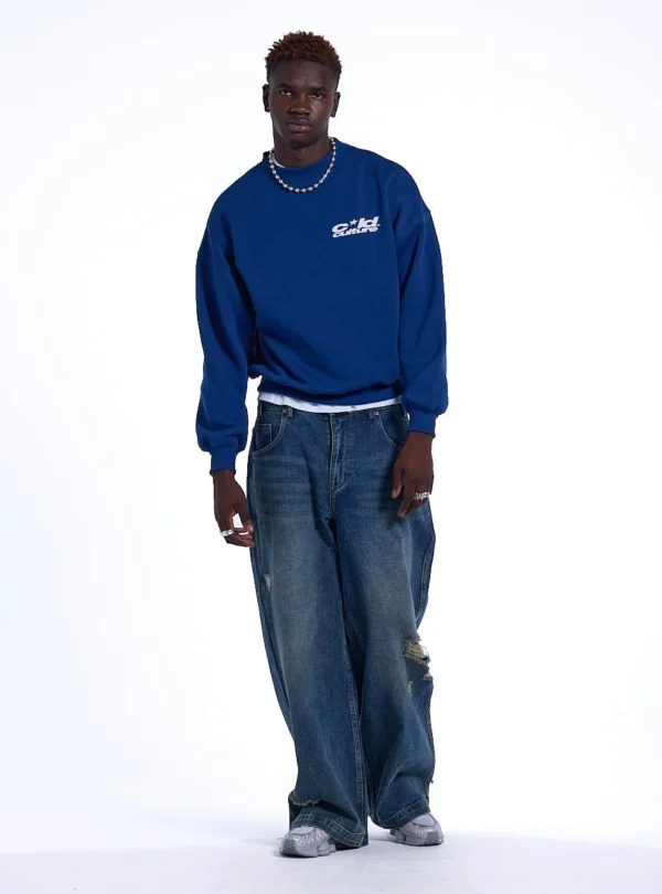 Modelo con sudadera sin capucha Heart Ashtray de Cold Culture en azul oscuro, mostrando el logotipo blanco del pecho