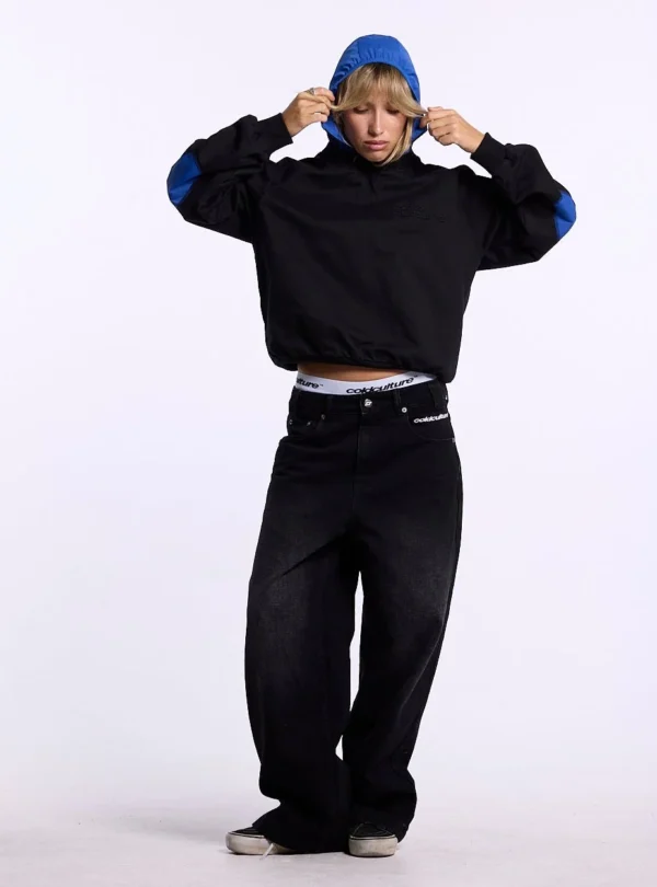 Modelo con sudadera sin capucha Cold Culture Intercept en negro y azul marino, con capucha azul y coderas a contraste