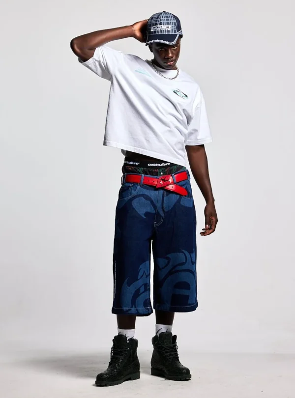 Cold Culture Laser Denim Shorts – Azul – Modelo de frente Modelo con shorts vaqueros azules Cold Culture Laser Denim con gráficos en la parte delantera