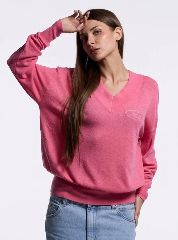 Cold Culture Lull Knit Mujer – Rosa – Detalle frontal con modelo Primer plano de modelo con jersey Lull Knit rosa de Cold Culture, mostrando el escote en pico, el logotipo tonal y el corte holgado.