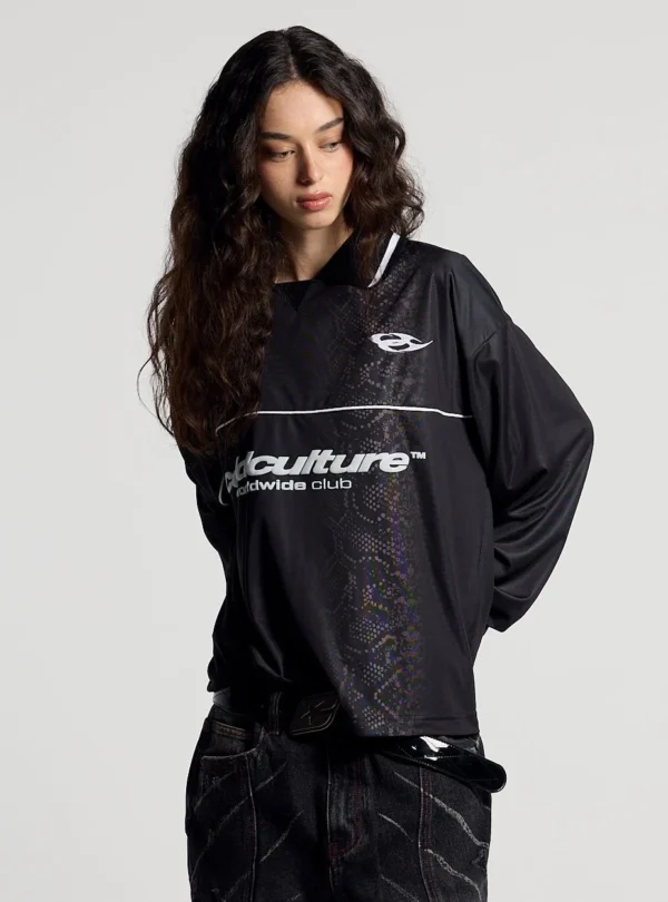 Modelo femenina con el Mamba Snake Longsleeve Polo negro de Cold Culture, de manga larga y corte holgado, con logotipo blanco y estampado de serpiente tonal.