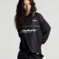 Modelo femenina con el Mamba Snake Longsleeve Polo negro de Cold Culture, de manga larga y corte holgado, con logotipo blanco y estampado de serpiente tonal.