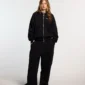 Modelo con pantalones deportivos negros Cold Culture Midnight Set de pernera ancha en vista frontal