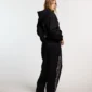 Modelo de espaldas con pantalones deportivos negros Cold Culture Midnight Set y logotipo vertical en la pernera