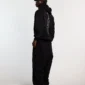 Modelo visto de espaldas con pantalones deportivos negros Cold Culture Midnight Set de corte ancho
