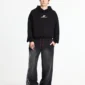 Modelo con pantalones deportivos Cold Culture Nighthunt negros de corte ancho, gráfico blanco lateral y cordones rojos
