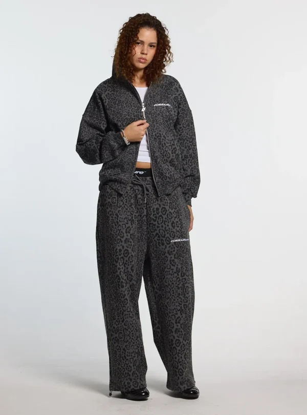 Modelo con pantalones deportivos Cold Culture Nocturne Beast en Dark Grey, estampado animal y logo blanco visible