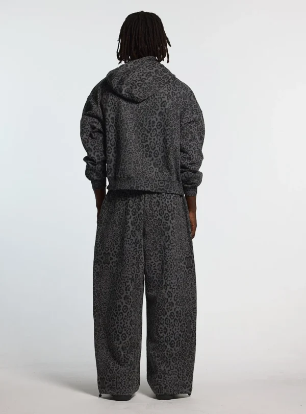 Modelo de espaldas con pantalones deportivos Cold Culture Nocturne Beast en Dark Grey con estampado animal y perneras anchas