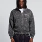 Modelo de frente con sudadera con cremallera Cold Culture Nocturne Beast gris oscuro, capucha puesta, estampado de leopardo y logo en el pecho.