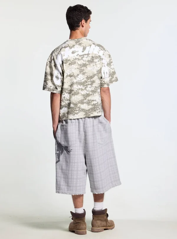 Modelo con shorts Novel de Cold Culture en gris vistos por detrás, con bolsillos traseros y gráfico lateral