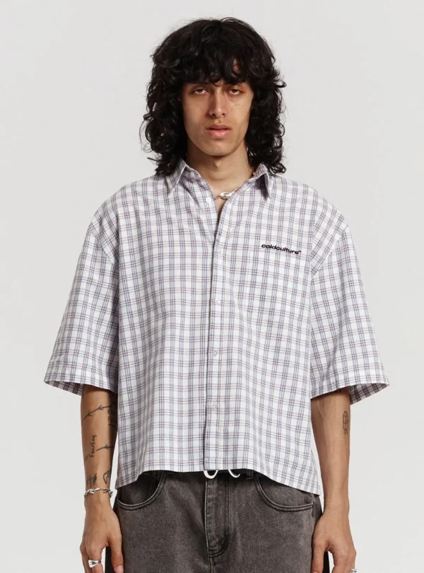 Modelo con la camisa One Pocket Camisa de Cold Culture en estampado Square Motif, con mangas cortas amplias, cuello abierto y logotipo en el pecho