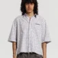 Modelo con la camisa One Pocket Camisa de Cold Culture en estampado Square Motif, con mangas cortas amplias, cuello abierto y logotipo en el pecho