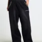 Detalle de los pantalones deportivos Cold Culture OPS negros con cintura de camuflaje, bolsillos ribeteados y logotipo blanco