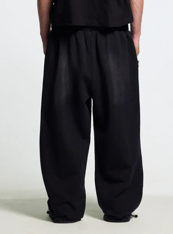 Detalle trasero de los pantalones deportivos Cold Culture OPS negros de pernera ancha con bajos ajustables