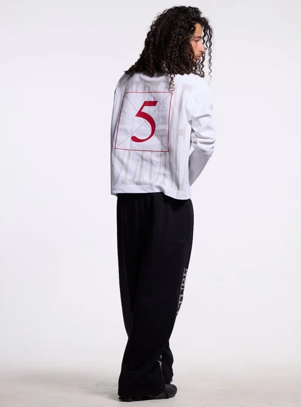 Cold Culture Pause Longsleeve Polo – Blanco – Modelo de espaldas Modelo de espaldas con el polo blanco Pause Longsleeve Polo de Cold Culture, mostrando el número 5 rojo y las letras grises de la parte trasera.