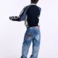Modelo de espaldas con jersey Pole Knit Navy de Cold Culture, mostrando los paneles en contraste, las rayas de las mangas y el cuello alto.