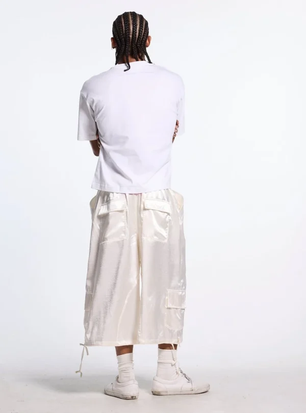 Modelo con Shorts Postal Capri de Cold Culture en color off-white, vistos por detrás con bolsillos traseros