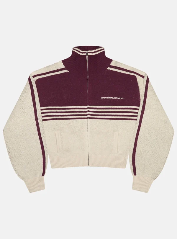 Jersey Powerline Zip Knit de Cold Culture en beige y burdeos, con cremallera frontal, cuello alto, rayas horizontales y logotipo en el pecho.