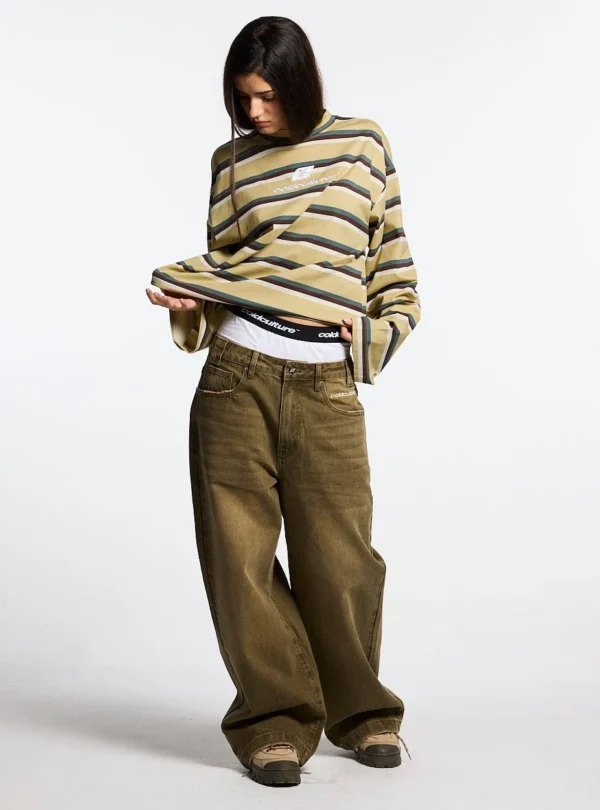 Modelo con manga larga Cold Culture Ray Curved amarilla y marrón mostrando el corte amplio y las mangas largas