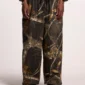 Modelo llevando los pantalones deportivos Cold Culture Realtree Black con estampado de camuflaje, vistos de frente