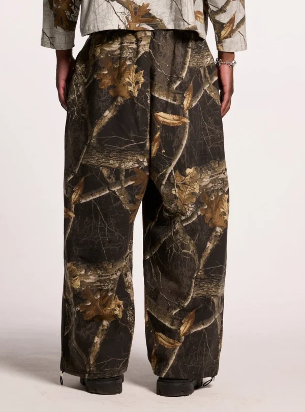 Modelo llevando los pantalones deportivos Cold Culture Realtree Black con estampado de camuflaje, vistos por detrás