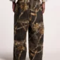 Modelo llevando los pantalones deportivos Cold Culture Realtree Black con estampado de camuflaje, vistos por detrás