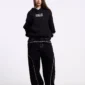 Modelo con pantalones negros Cold Culture Roller V2 Denim de corte holgado, con costuras blancas en vista frontal