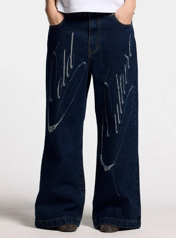 Vista frontal de los pantalones Cold Culture Script V3 en Raw Denim con corte de pernera ancha y gráficos desgastados