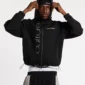 Modelo llevando la sudadera con cremallera negra Cold Culture Scuba con la capucha puesta y logotipos blancos frontales