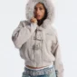 Primer plano frontal del abrigo Cold Culture Shackle Bomber Off White con capucha de pelo, hebillas metálicas y bolsillo con cremallera en el pecho.