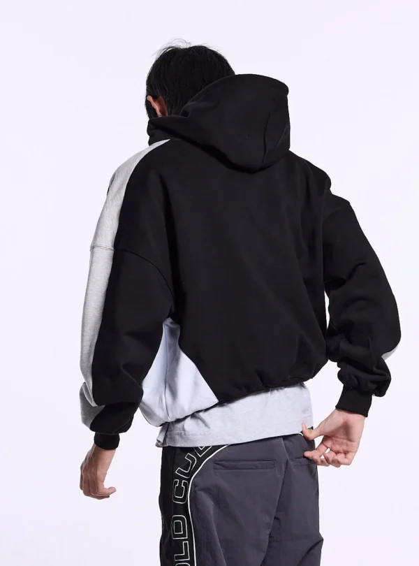 Vista trasera de la sudadera Speed Spoke de Cold Culture puesta en un modelo, con espalda negra, capucha y paneles grises y blancos en las mangas y laterales.