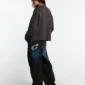 Modelo femenina de espaldas con jersey Spider Knit gris de Cold Culture, mostrando el corte holgado y la parte trasera lisa.