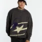 Modelo con jersey Spider Knit gris de Cold Culture, de corte amplio y gráfico de araña morada con detalles en crema.