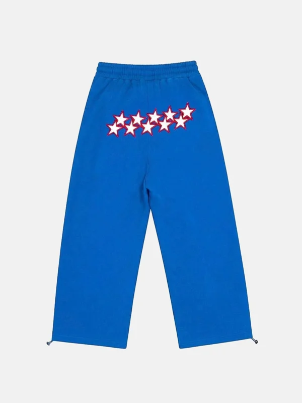Vista trasera de los pantalones Stars Deportivos Blue de Cold Culture en azul, con estrellas blancas de contorno rojo y perneras anchas.