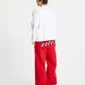 Modelo de espaldas con pantalones deportivos rojos Stars de Cold Culture, con estrellas blancas y negras en la parte trasera y perneras holgadas.