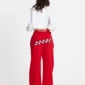 Modelo femenina de espaldas con pantalones deportivos rojos Stars de Cold Culture, decorados con estrellas blancas de borde negro en la parte posterior.