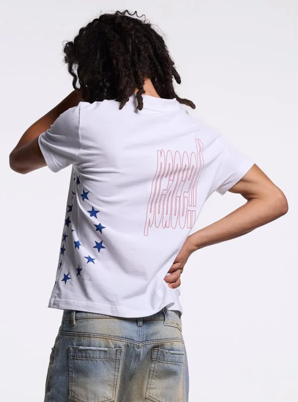 Detalle trasero del polo blanco Starttrail de Cold Culture en modelo masculino, con gráfico Peace de contorno rojo y estrellas azules.