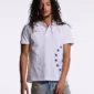 Vista frontal de un modelo con polo blanco Starttrail de Cold Culture que muestra el cuello de botones, el logotipo rojo y las estrellas azules.
