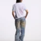 Modelo femenina de espaldas con polo blanco Starttrail de Cold Culture, estampado Peace rojo en la espalda y estrellas azules en el lateral.