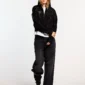 Modelo con sudadera con cremallera negra Cold Culture Stud, capucha puesta y detalles de tachuelas metálicas