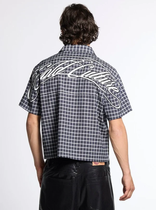 Modelo de espaldas con camisa Tartan Script negra de Cold Culture, estampado de cuadros y gran gráfico blanco de la marca sobre los hombros