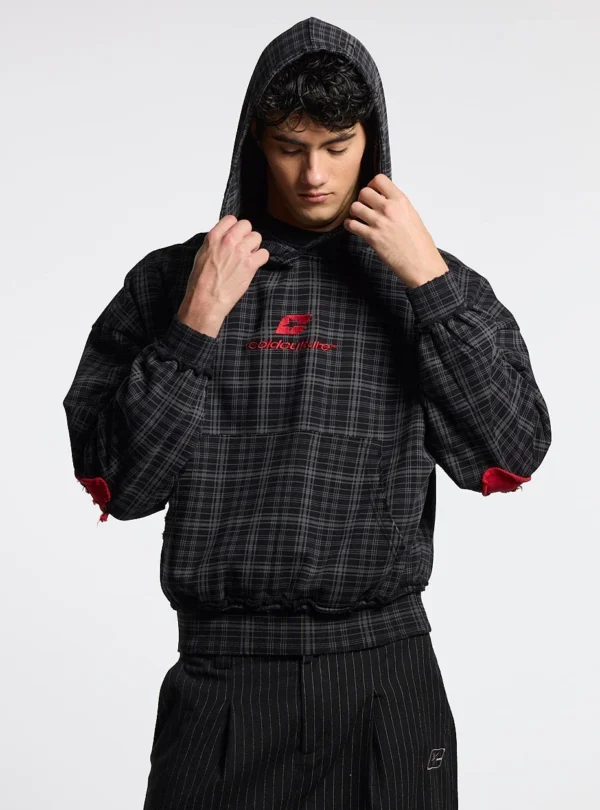 Cold Culture Tartan Sudadera – Black – Modelo con capucha Modelo con sudadera negra Tartan de Cold Culture a cuadros, capucha puesta, logo rojo y bolsillo canguro