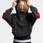 Modelo con sudadera negra Tartan de Cold Culture a cuadros, capucha y detalles rojos en las mangas