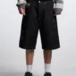 Detalle frontal de las bermudas Toxic de Cold Culture en Black Denim con efecto desgastado y bolsillo con aplicación de cuadros