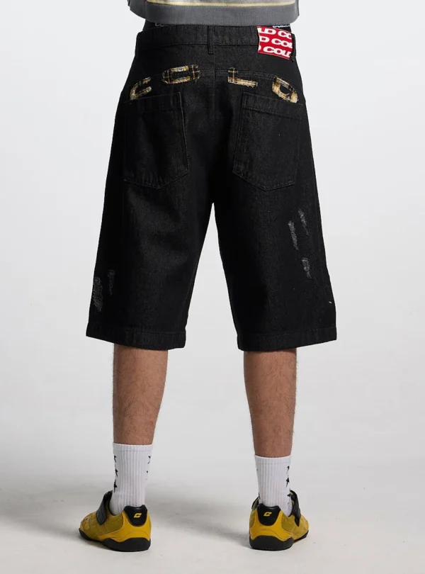 Detalle trasero de las bermudas Toxic de Cold Culture en Black Denim con bolsillos, aplicaciones de cuadros y etiqueta roja