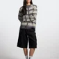 Modelo con bermudas Toxic de Cold Culture en Black Denim, look frontal con corte amplio y detalles desgastados