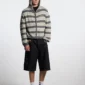 Modelo con bermudas Toxic de Cold Culture en Black Denim, vista frontal mostrando el corte amplio y los detalles desgastados