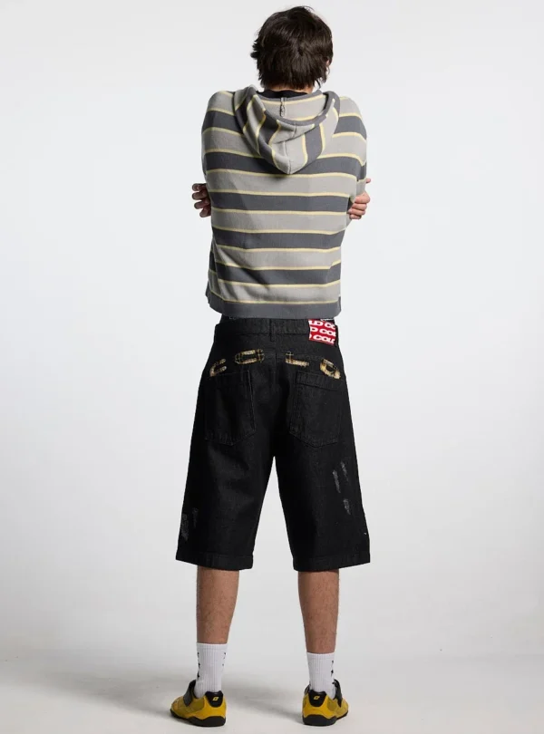 Modelo con bermudas Toxic de Cold Culture en Black Denim, vista trasera con bolsillos y aplicaciones de cuadros